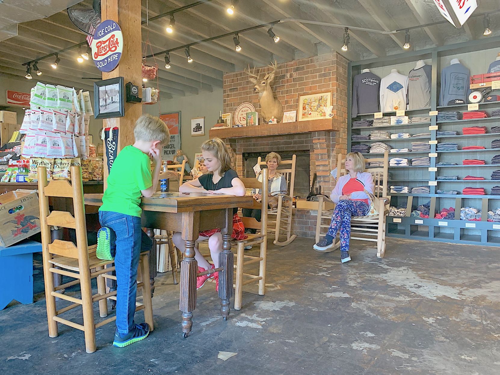 Customers sit and stay a spell inside Scotsman Co. Branch Boyer and Celeste Adams play a game while Eva Adams and Peggy McKay try out some rocking chairs. (Photo by Tori Ellis).jpg